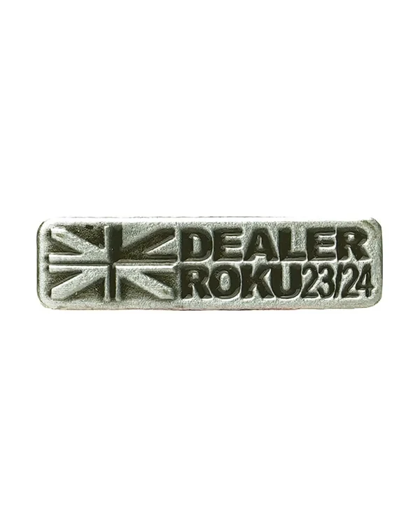 Firemní odznak „Dealer roku 23/24“ — oxidovaný stříbrný odlitek s reliéfním nápisem, ocenění pro obchodního partnera